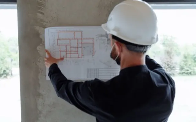 Inżynier analizujący projekt budowlany na budowie